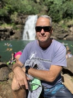 Man in t-shirt in front of waterfall